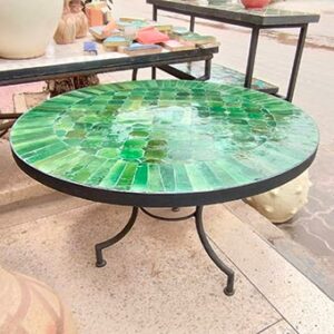 Photo d'une table en fer forgé avec un plateau en zellige, c'est un assemblage de pièces de faïence, mosaïque entièrement taillé et incrusté sur un support en mortier.