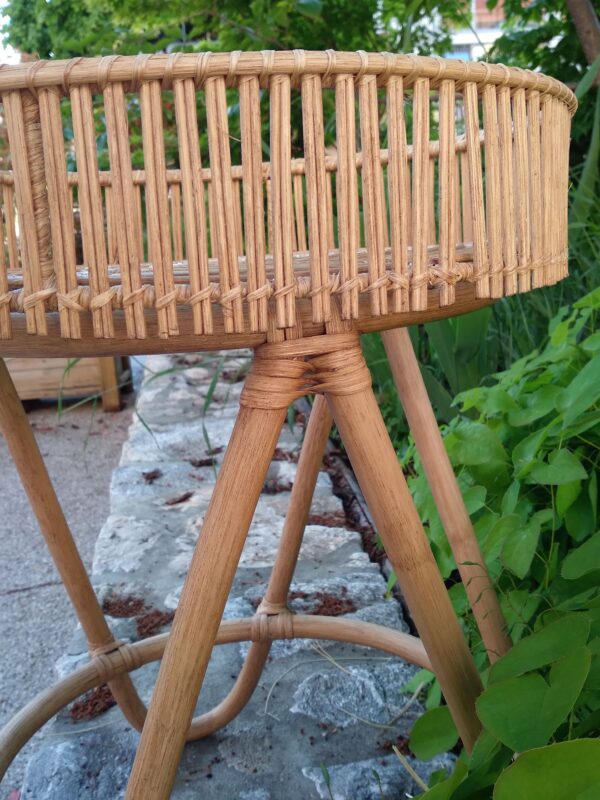 Photo d'une table en osier, peut servir de bout de canapé, belle facture, cette table est joliment réalisé. Le rebord qui l'entour protège les objets posé dessus.