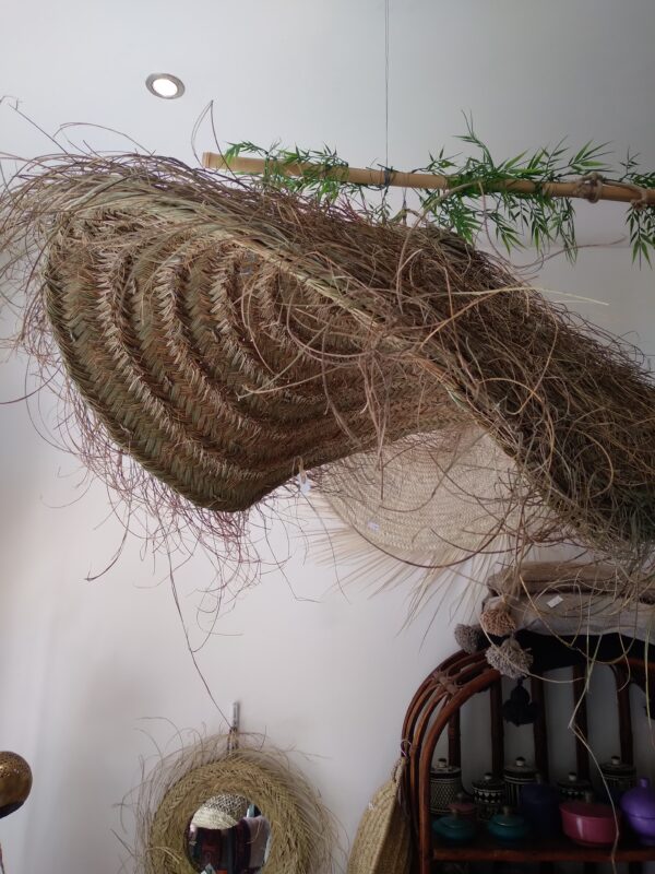 Photo d'un suspension en doum soleil XXL ( palmier nain ) tressé. forme arrondie, plate et aérienne.