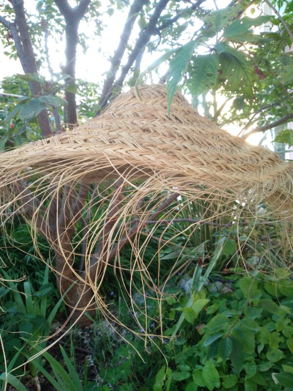 Photo d'un suspension en doum ( palmier nain ) tressé. forme arrondie, plate et aérienne.