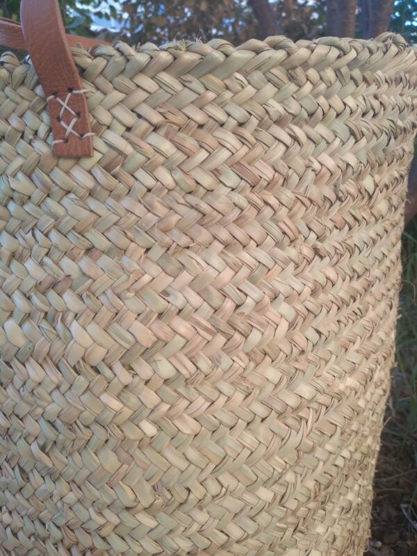 Photo d'un panier à linge en fibre végétale de palmier avec anses en cuir. Très utilisé au Maroc pour la vannerie. Il est résistant, ne craint pas l'eau, il devient un vrai allié pour tout ranger dans la maison.