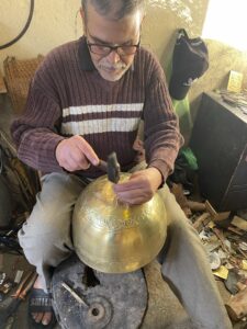 Photo d'un artisan à Marrakech travaille du cuivre.