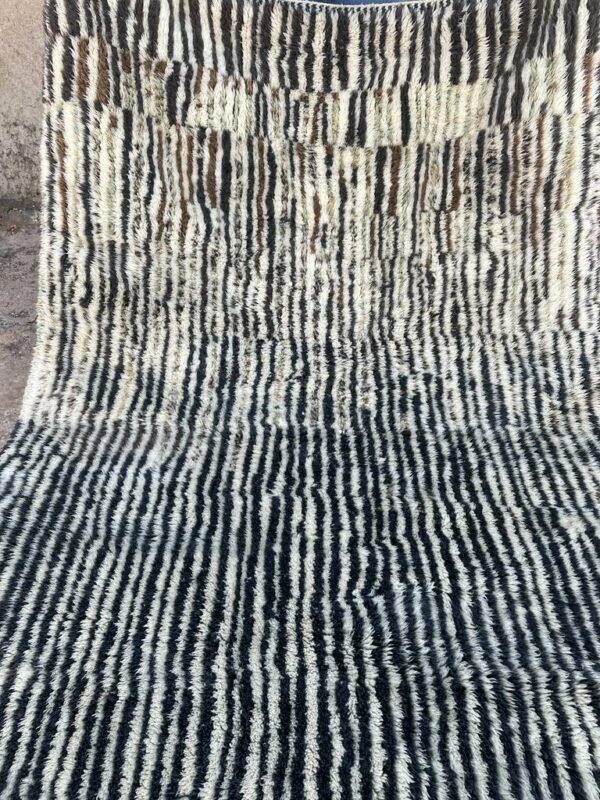 Photo d'un tapis Mrirt rayé camaïeu de bleu et gris, ligne géométrique, sur fond écru. Les tapis Mrirt sont tissé avec des nœuds doubles ce qui en fait des tapis particulièrement dense. 200 x 150. 650€
