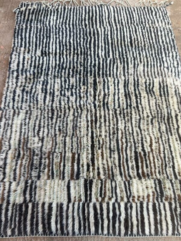 Photo d'un tapis Mrirt rayé camaïeu de bleu et gris, ligne géométrique, sur fond écru. Les tapis Mrirt sont tissé avec des nœuds doubles ce qui en fait des tapis particulièrement dense. 200 x 150. 650€