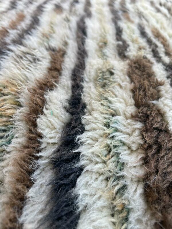 Photo d'un tapis Mrirt rayé camaïeu de bleu et gris, ligne géométrique, sur fond écru. Les tapis Mrirt sont tissé avec des nœuds doubles ce qui en fait des tapis particulièrement dense. 200 x 150. 650€
