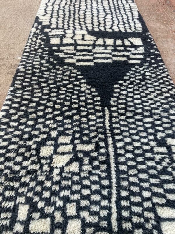 Photo d'un tapis Mrirt couloir motifs noir sur fond blanc 275X100 motif gratte ciel, le tapis Mrirt est un tapis tissé avec des doubles nœuds ce qui en fais un tapis dense et doux. Il est un des plus beau tapis contemporain du Maroc.