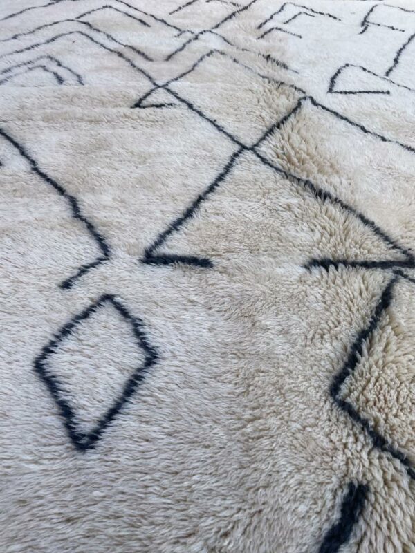 Photo d'un Tapis Mrirt à poil long ( Shaggy ) motif en forme de montagne. Tapis couleur écru et motifs noirs. 300x250.