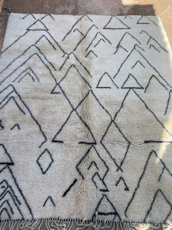 Photo d'un Tapis Mrirt à poil long ( Shaggy ) motif en forme de montagne. Tapis couleur écru et motifs noirs. 300x250.