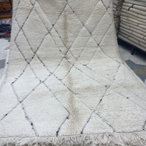 Photo d'un tapis Beniouarain blanc motifs géométrique dans la trame.