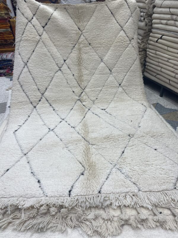 Photo d'un tapis Beniouarain blanc motifs géométrique dans la trame.