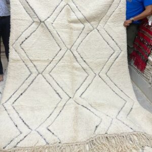 Photographie d'un tapis Beni-Ouarain 225 x 165 écru et losange noirs dans la trame.