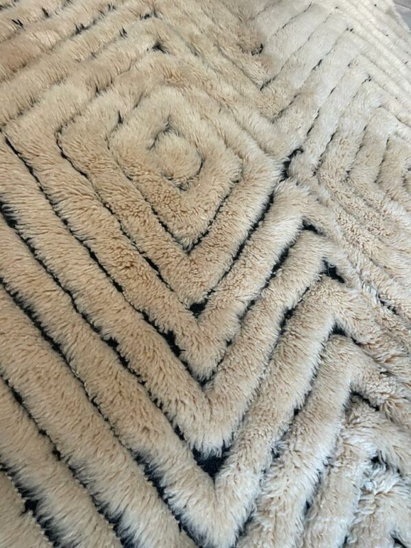 Photographie d'un tapis Mrirt couleur miel sur fond noir.