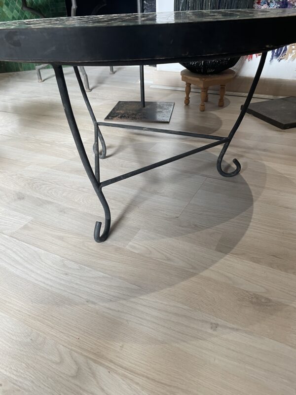 Photo d'une table ronde en zellige turquoise et noir.