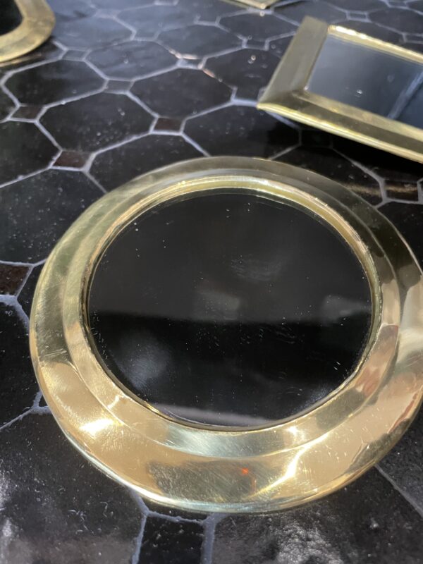 Photographie d'un miroir à sac avec un contour cuivre, en forme rond.