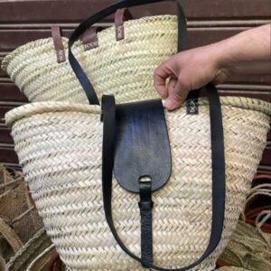 Photo d'un panier en palmier et rabats en anses en cuir.