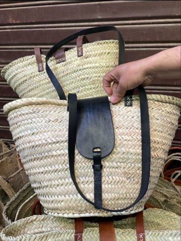 Photo d'un panier en palmier et rabats en anses en cuir.