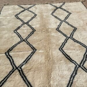 Tapis Mrirt éxposé au sol losanges noirs, sur fond écru de la laine naturelle. Desing épurés.
