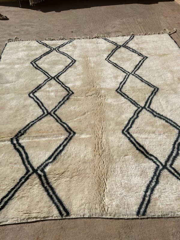Tapis Mrirt éxposé au sol losanges noirs, sur fond écru de la laine naturelle. Desing épurés.
