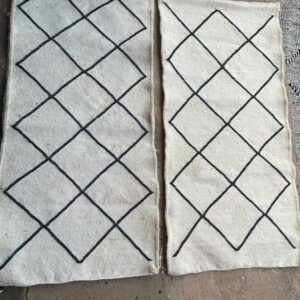Photo de deux descente de lit 100x60 tapis Beni-Ouarain tissé type kilim blanc losange noir.