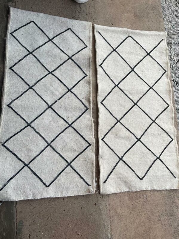 Photo de deux descente de lit 100x60 tapis Beni-Ouarain tissé type kilim blanc losange noir.