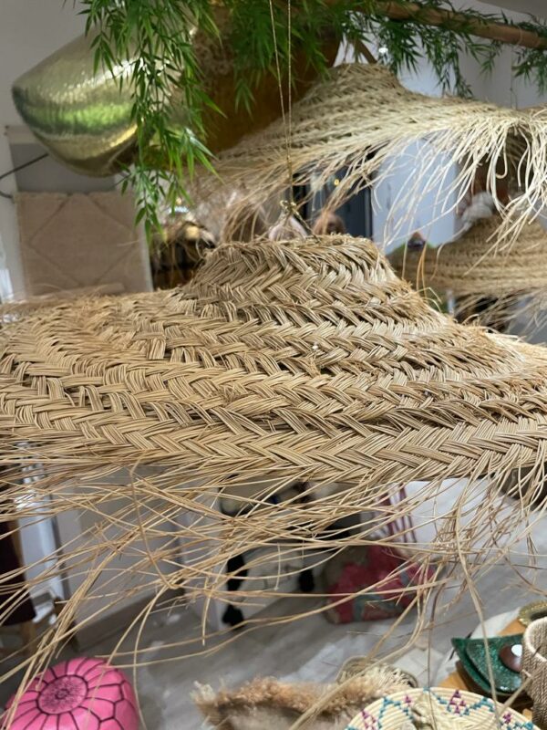 Photographie d'une suspension en doum ( palmier nain ) tressé. forme arrondie, plate et aérienne.