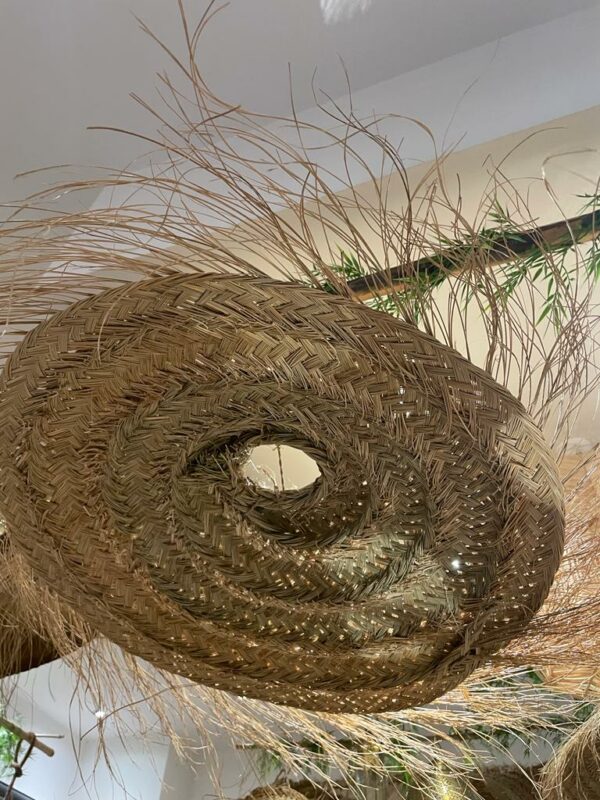 Photographie d'une suspension en doum ( palmier nain ) tressé. forme arrondie, plate et aérienne.