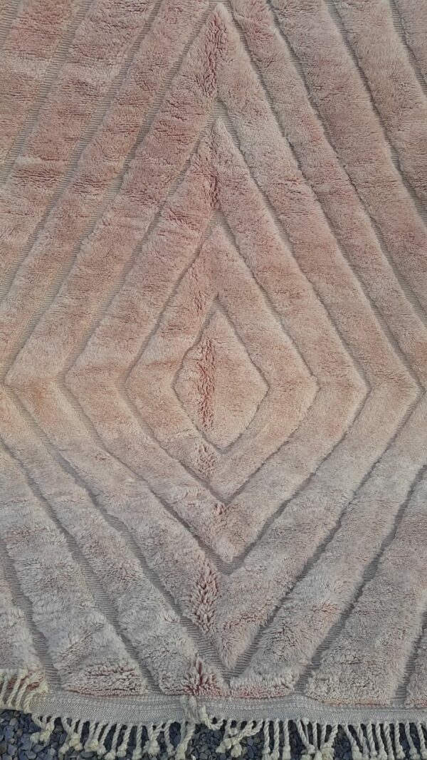 Photo d'un tapis Mrirt beige rosé. 310x215. Tapis entièrement réalisé en laine, avec des doubles nœuds, il est dense, épais, sa texture est douce et soyeuse. Le tapis Mrirt est le tapis contemporain le plus luxueux est un des plus beau du Maroc. confectionné dans les montagnes du moyen Atlas.