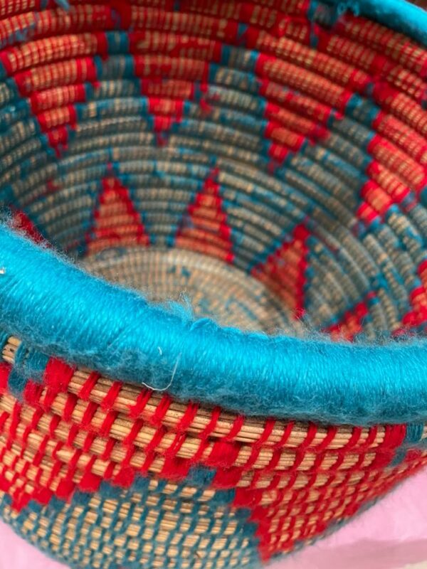 Photo d'un panier à linge en doum couleur bleu et rouge.