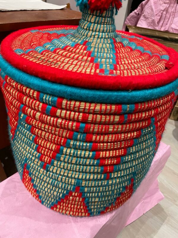 Photo d'un panier à linge en doum couleur bleu et rouge.