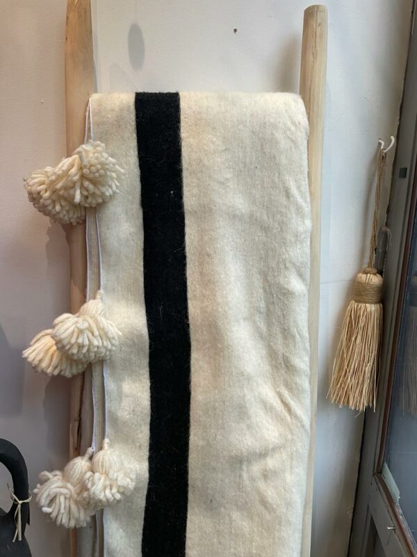 Photo d'un plaid en laine écru ligne noire.