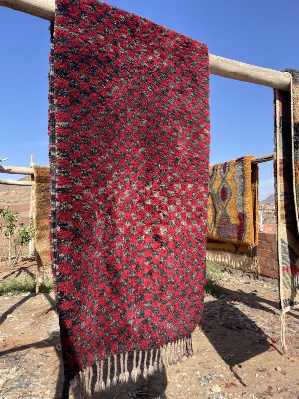 Tapis Mrirt couloir damier étendue sur des rondins de bois pour le sechage du tapis.