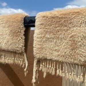 Tapis Mrirt beige éclat soleil disposé sur des rondins de bois pour un sechage au soleil