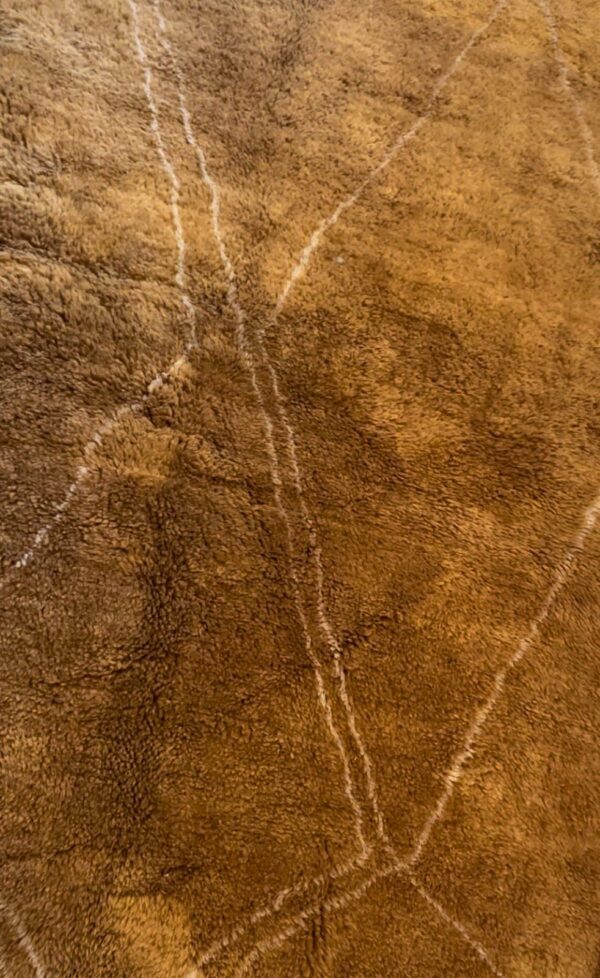 Zoom sur la texture du tapis Mrirt couleur caramel et ses motifs discrets.