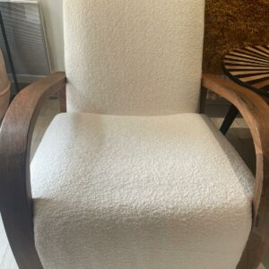 Photo d'un fauteuil en bois de noyer et tissu bouclette écru.