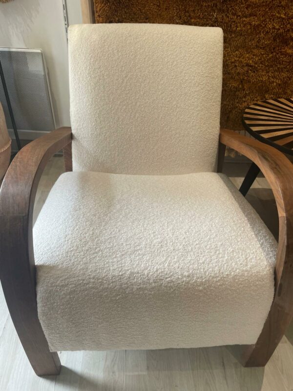 Photo d'un fauteuil en bois de noyer et tissu bouclette écru.