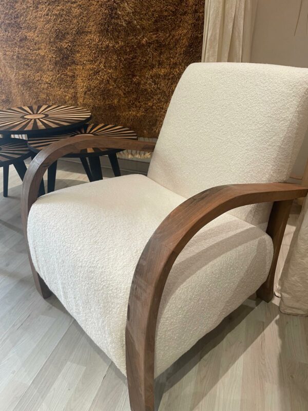Photo d'un fauteuil en bois de noyer et tissu bouclette écru.